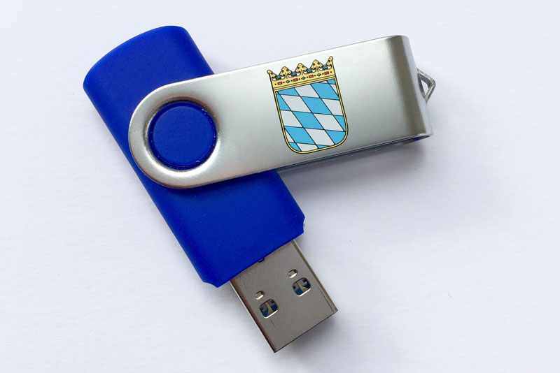 Aufgeklappter USB-Stick mit dem Staatswappen. 